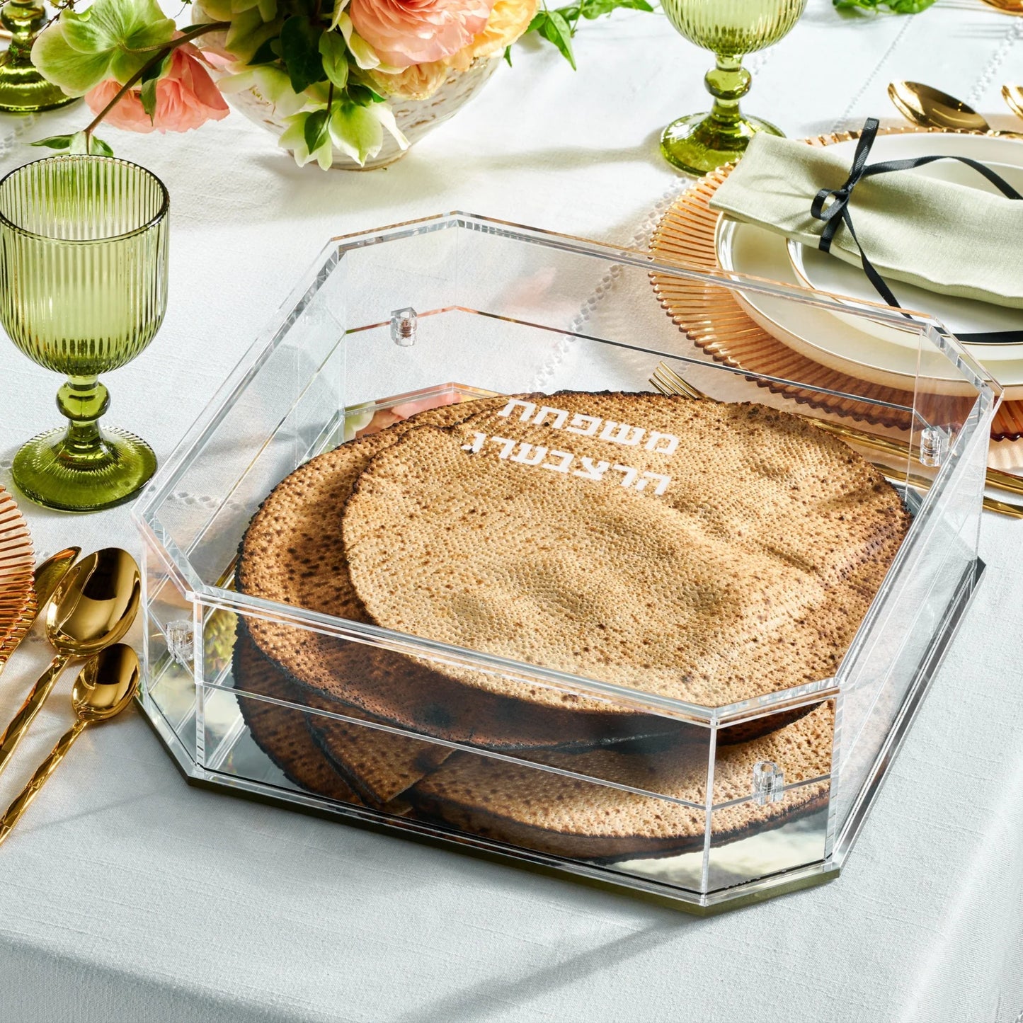 Hexagonal matzah box with a round matzah on a table setting with green glasses and gold spoons -AFH Bargains